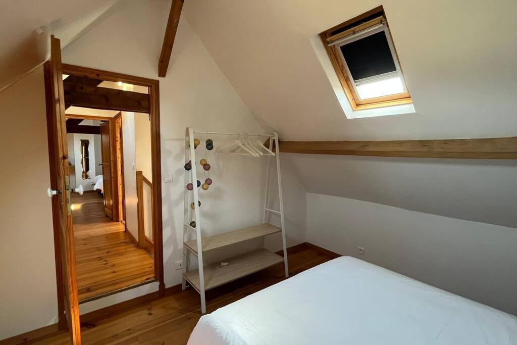 a attic room with a bed and a window and a ladder at La Reinette du Verger 9 d&#39;Arry 1 in Arry