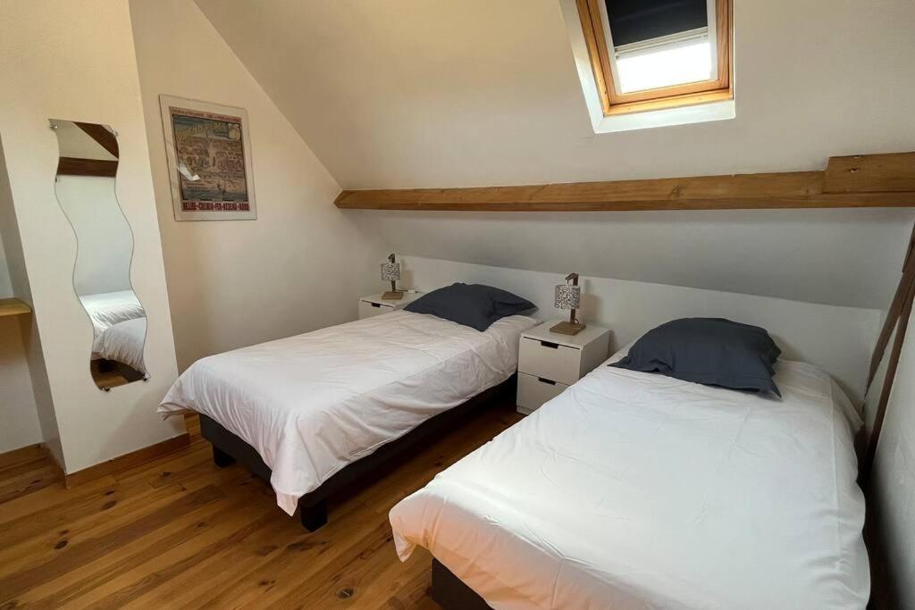 a bedroom with two beds and a window at La Reinette du Verger 9 d&#39;Arry 1 in Arry