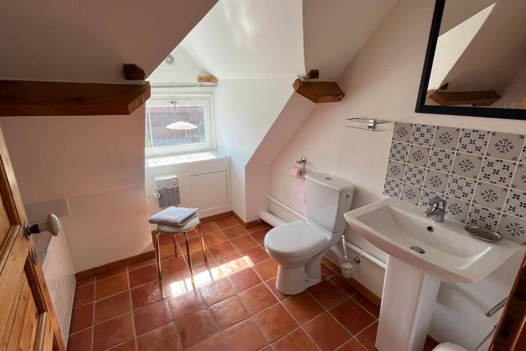 a bathroom with a white toilet and a sink at La Reinette du Verger 9 d&#39;Arry 1 in Arry