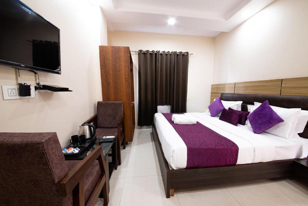 a hotel room with a bed and a television at Perfect Stayz Dwarkesh - Hotel Near Haridwar Railway station in Haridwār