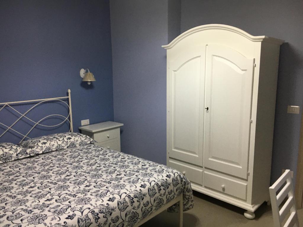 um quarto com uma cama e um armário branco em Azienda agricola Crilù em Milazzo