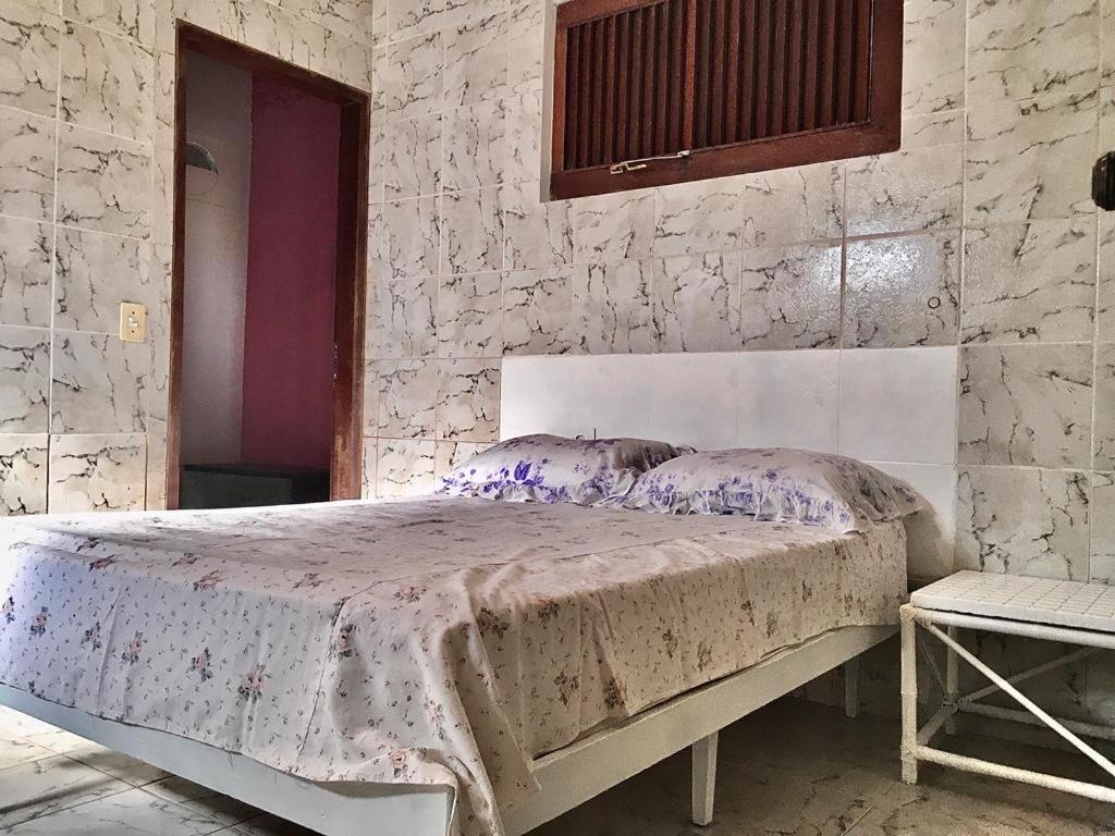 a bedroom with a bed in a stone wall at Falésias de Carapibus in Conde