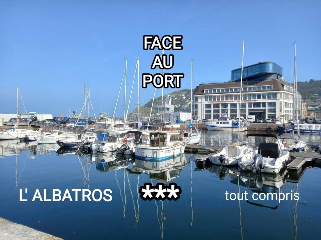 een jachthaven met boten in het water en een gebouw bij L' ALBATROS vue sur le port in Fécamp
