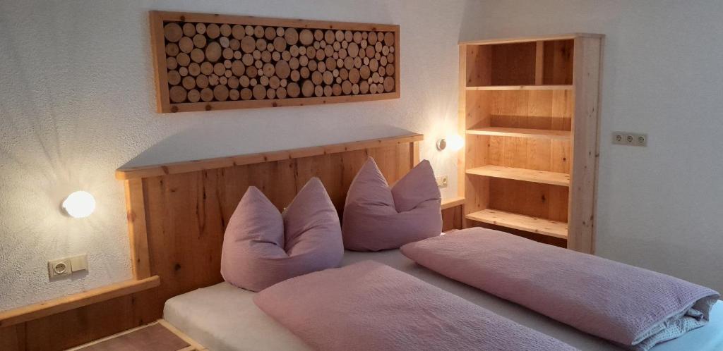 una camera da letto con un letto con cuscini rosa di Haus Rottensteiner a Jerzens