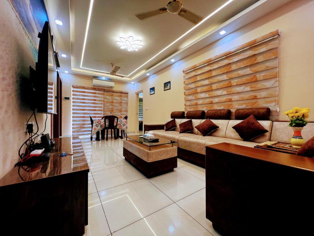a living room with a couch and a table at Exquisite 2BHK de Luxe boutique apartment. in Kulurkudrū
