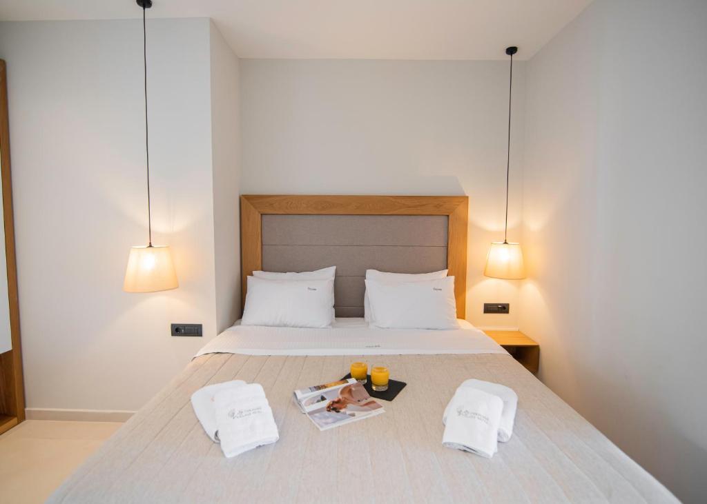 a bedroom with a bed with two towels and a magazine at Chrousso Village in Paliouri