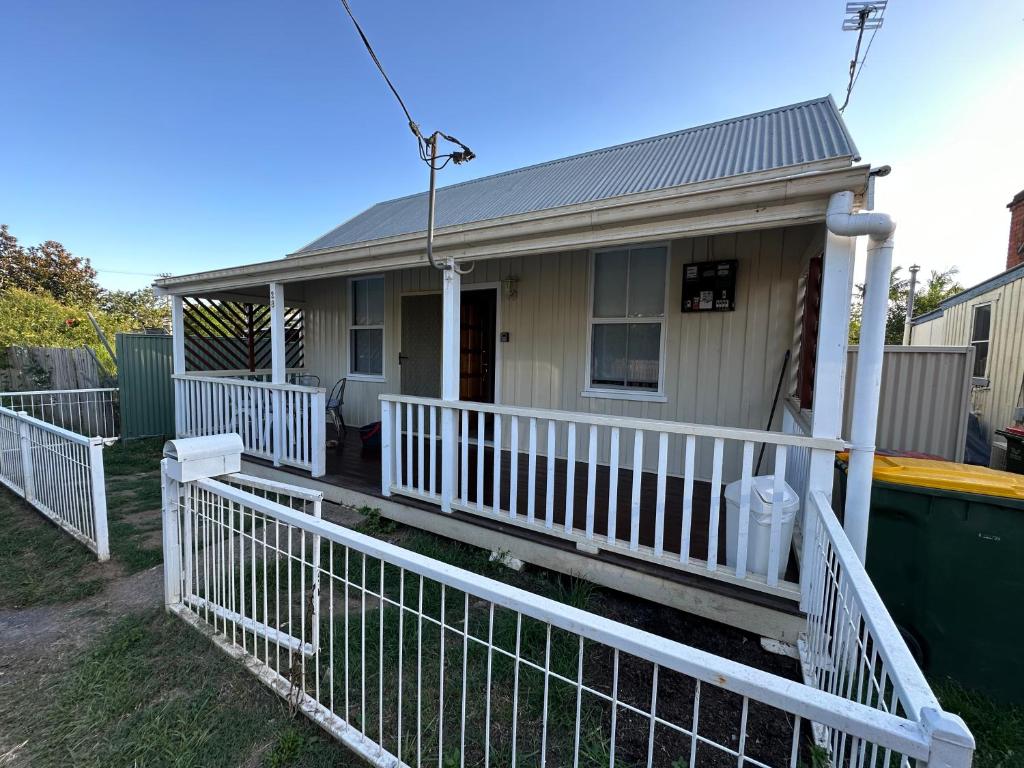 a house with a white fence in front of it at Charming 3 bedroom Workers Accommodation in Grafton