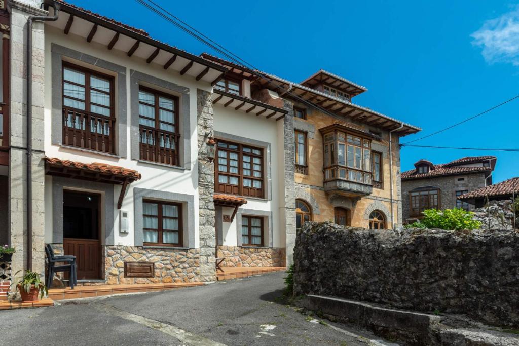 uma casa velha com uma cerca em frente em Casa Rural La Indiana I y II em Porrúa