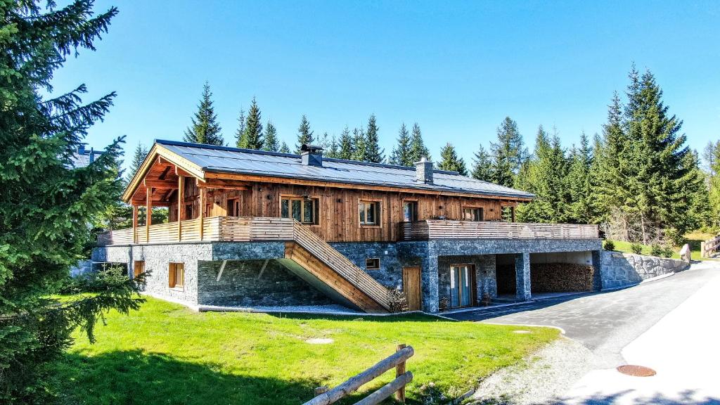 Una gran casa de madera con una escalera delante de ella en Chalet Hochkrimml 43, en Krimml