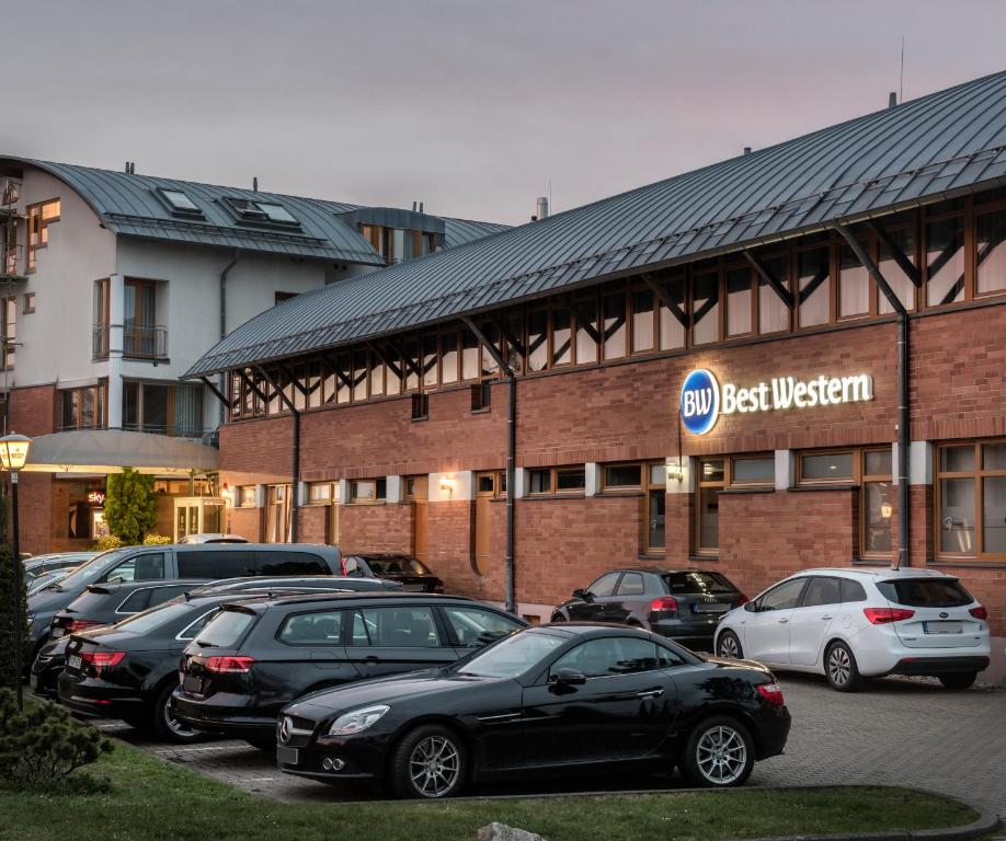 ein Parkplatz mit Autos vor einem Gebäude in der Unterkunft Best Western Hotel Braunschweig Seminarius in Braunschweig