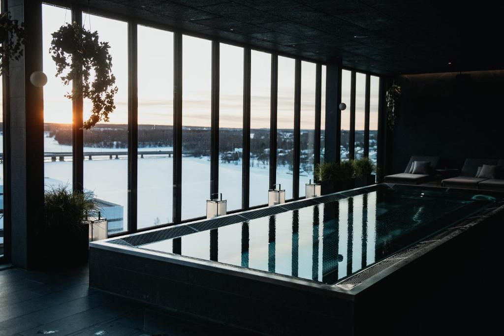 a swimming pool in a building with a large window at Clarion Hotel Umeå in Umeå