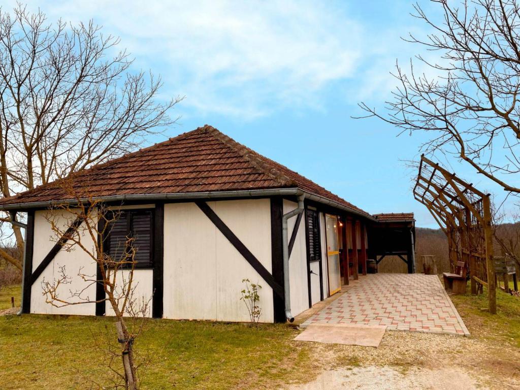 un petit bâtiment blanc avec un toit brun dans l'établissement Ruralna kuća za odmor Klet Karas, à Kozarevac