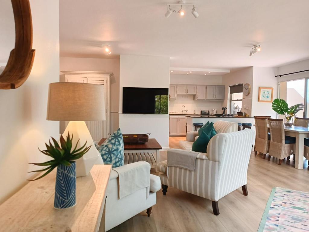 uma sala de estar com um sofá e uma mesa em Lagoon Terrace 14 em Plettenberg Bay