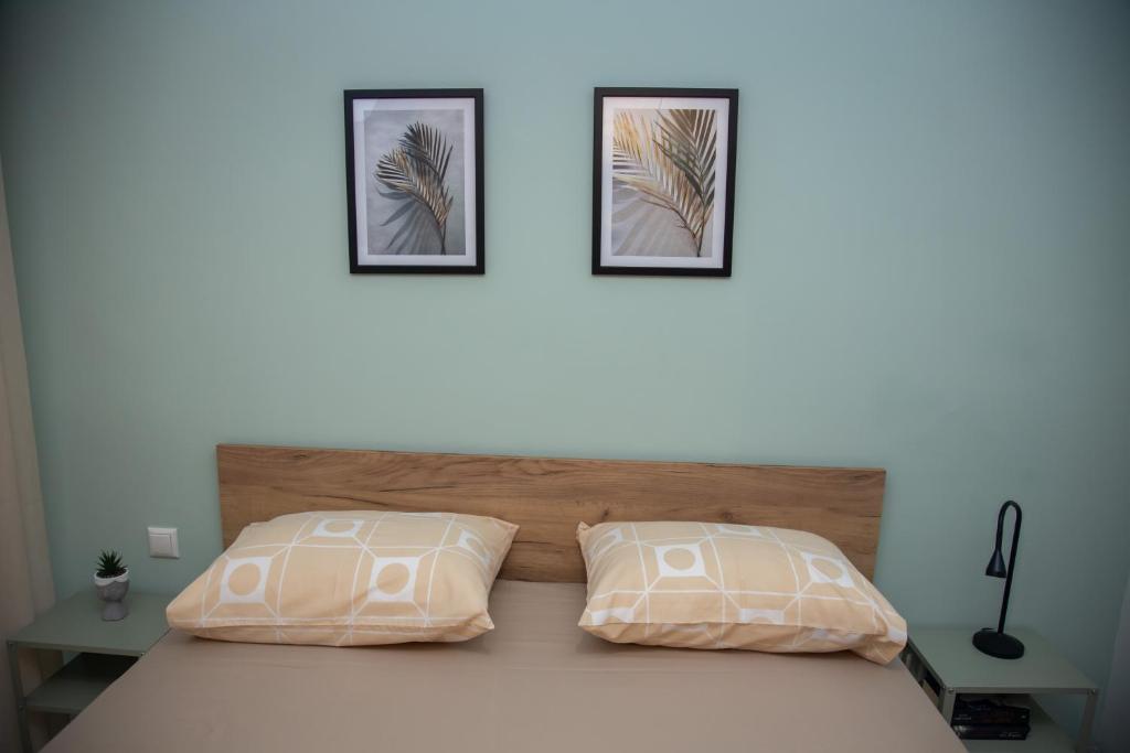 a bedroom with a bed with two pictures on the wall at Fobillo Apartment at Charilaou in Thessaloniki