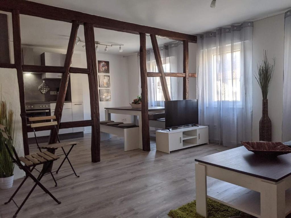 een woonkamer met een televisie en een tafel en stoelen bij Ferienwohnung Zundel in Neu-Anspach