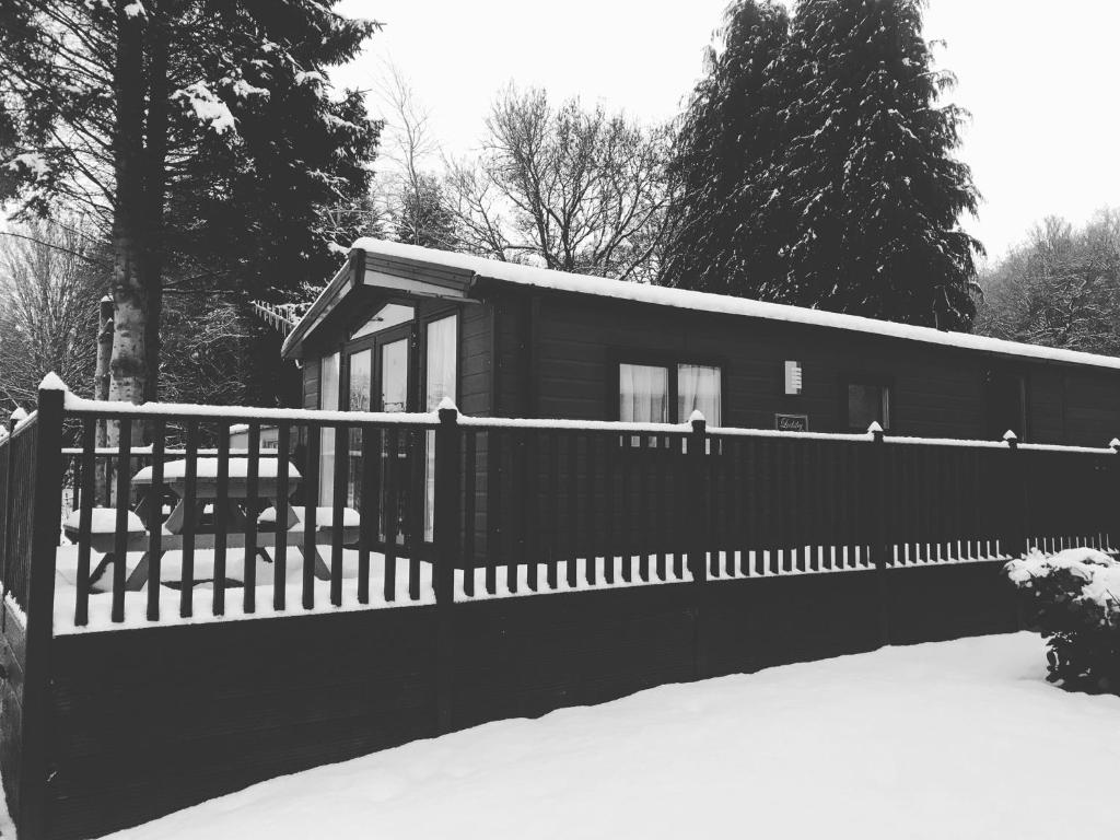 a house with a fence in the snow at Ravenwood Lodge in Dollar