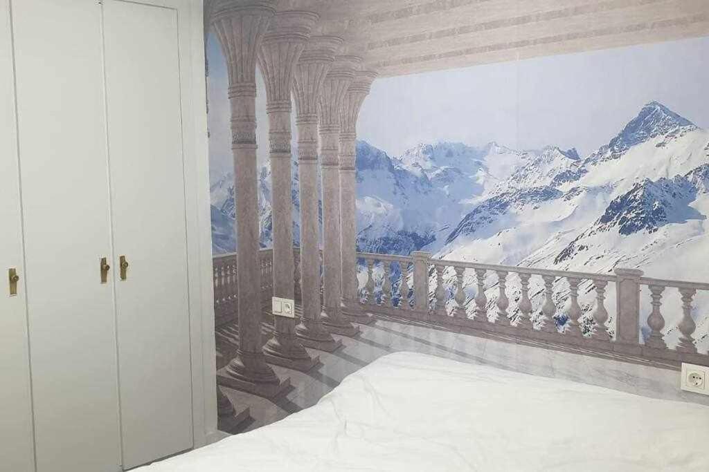una habitación con una pintura de un edificio con una montaña en Acogedor apartamento en el Pirineo aragonés, en Villanúa