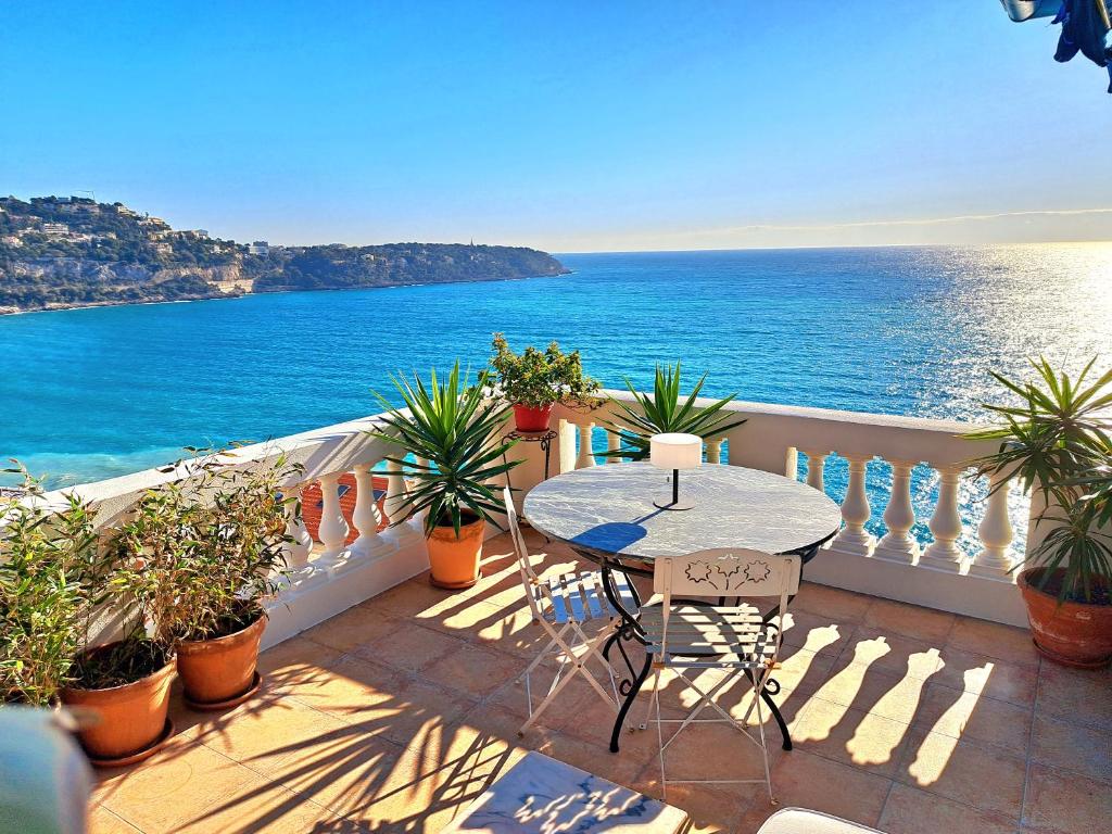 balkon ze stołem i widokiem na ocean w obiekcie Sea view studio terrasse Cap Martin/Monaco w mieście Roquebrune-Cap-Martin