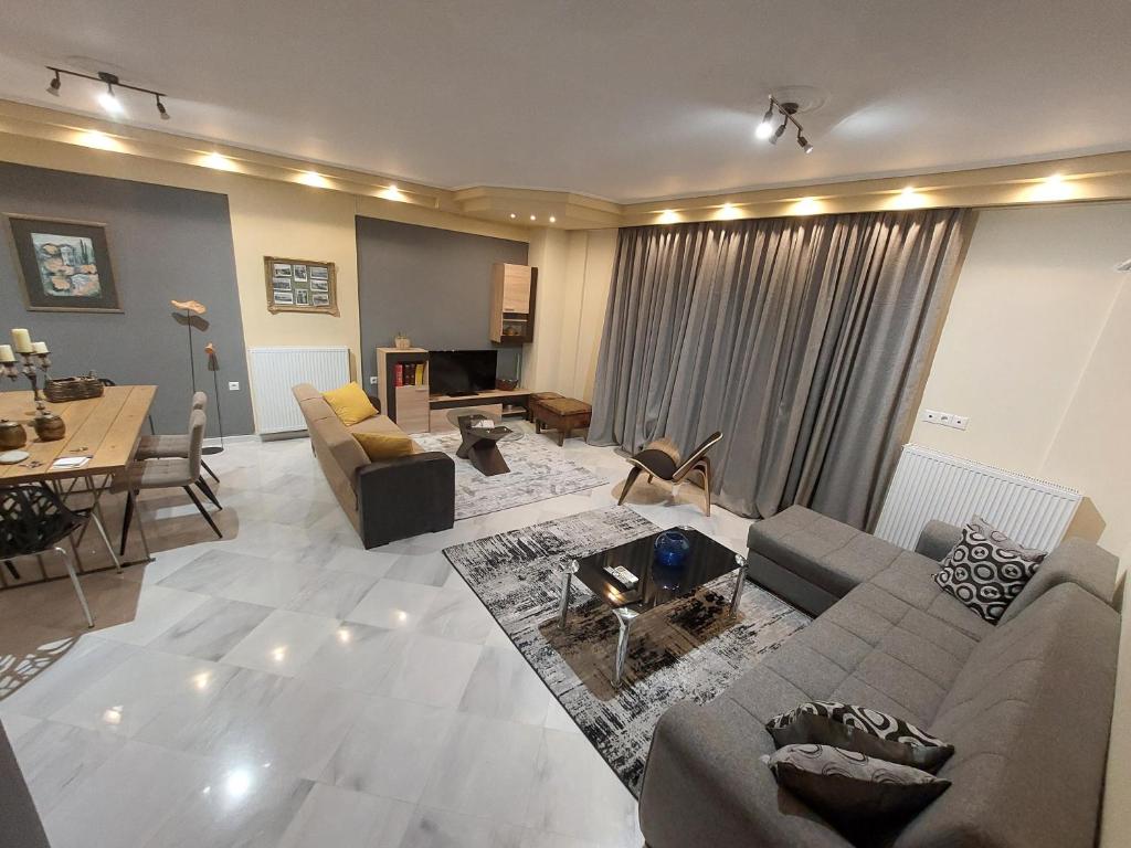 central luxury apartment في فولوس: غرفة معيشة مع أريكة وطاولة