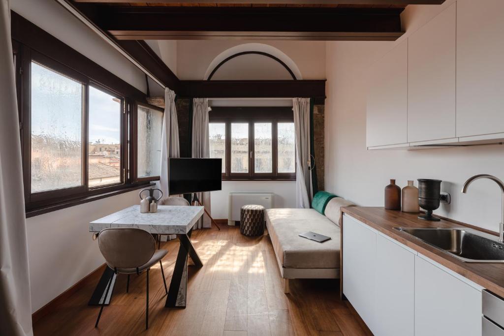 a kitchen and living room with a table and a couch at Torre Capranica in Rome