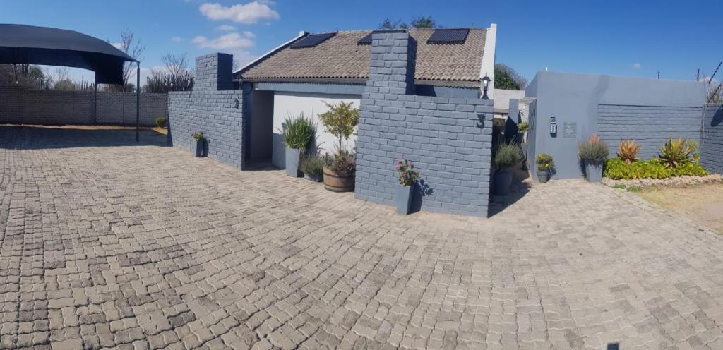 a house with a brick driveway and a garage at Sheilas Self-Catering Overnight Accommodation in Polokwane