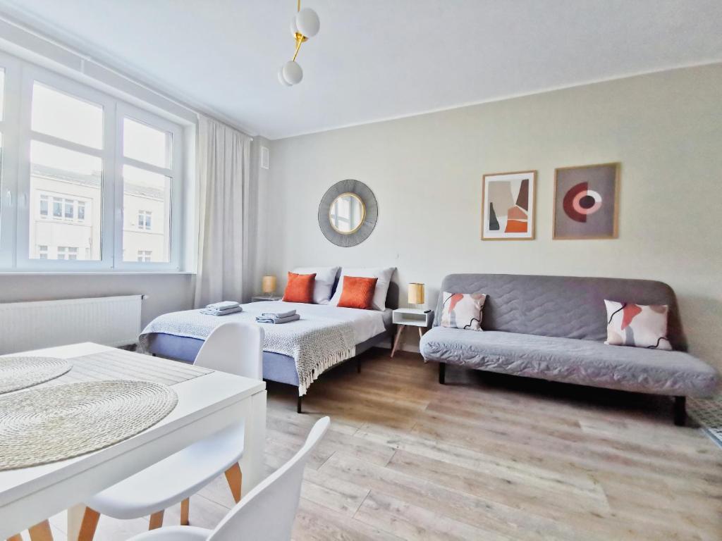 salon z kanapą i łóżkiem w obiekcie Apartamenty Świętojańska Gdynia Centrum w mieście Gdynia