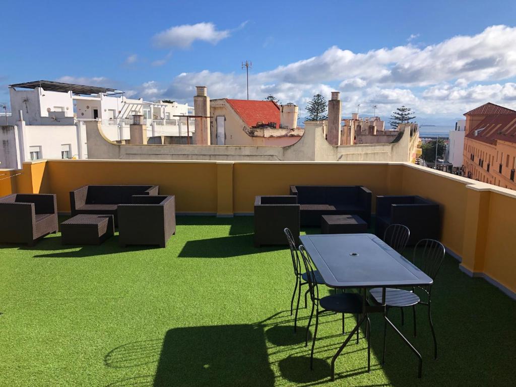 een terras met een tafel en stoelen op een dak bij 2 Bedrooms and sofa bed flat by Wayra Tarifa in Tarifa