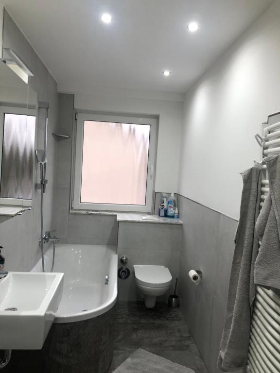 ein Bad mit einem Waschbecken, einem WC und einem Fenster in der Unterkunft Zentrale Unterkunft in Dortmund City in Dortmund