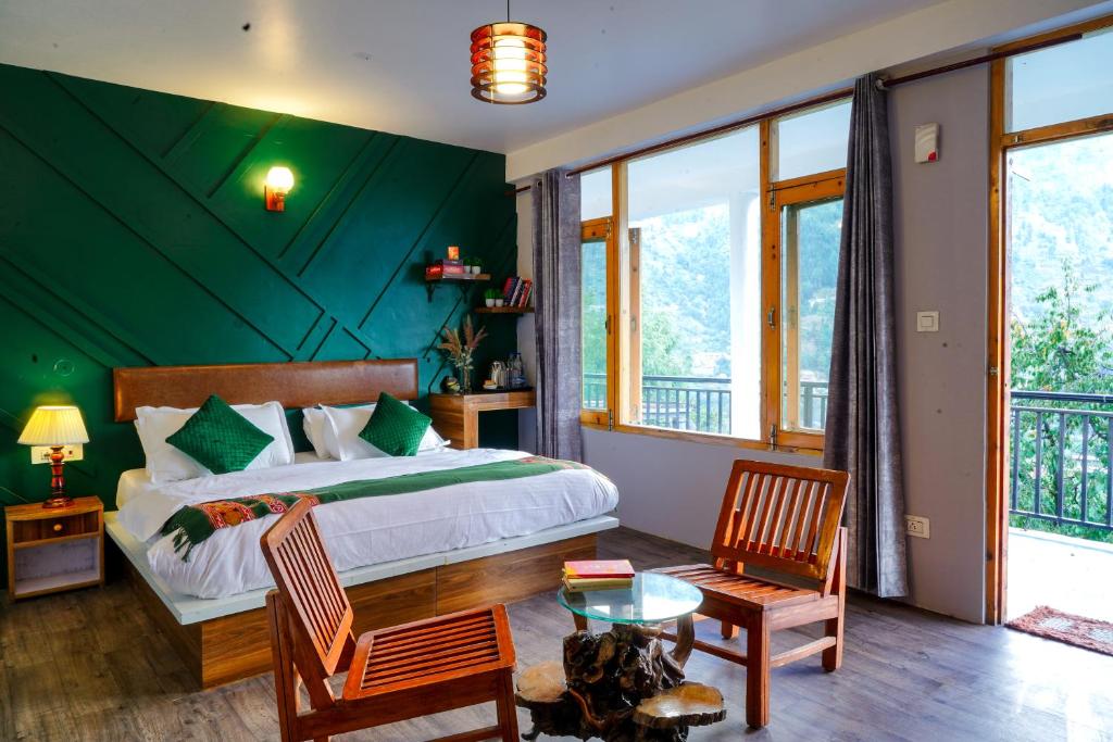 1 dormitorio con 1 cama con pared verde en Bros Hostel & Yaara Cafe, en Manali