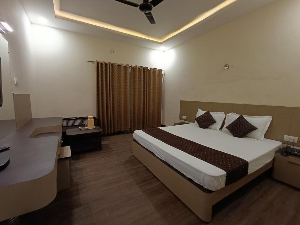 um quarto de hotel com uma cama e uma secretária e uma cama sidx sidx em Hotel Padmini International- Sigra em Kakarmatha