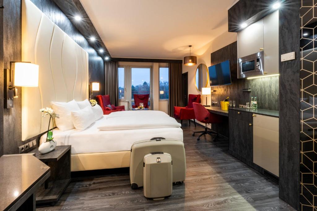 ein Hotelzimmer mit einem Bett und einer Küche in der Unterkunft PLAZA Premium Schwerin Sure Hotel Collection by Best Western in Schwerin