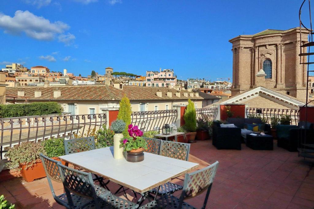 a patio with a table and chairs and a city at Spagna Penthouse in Rome