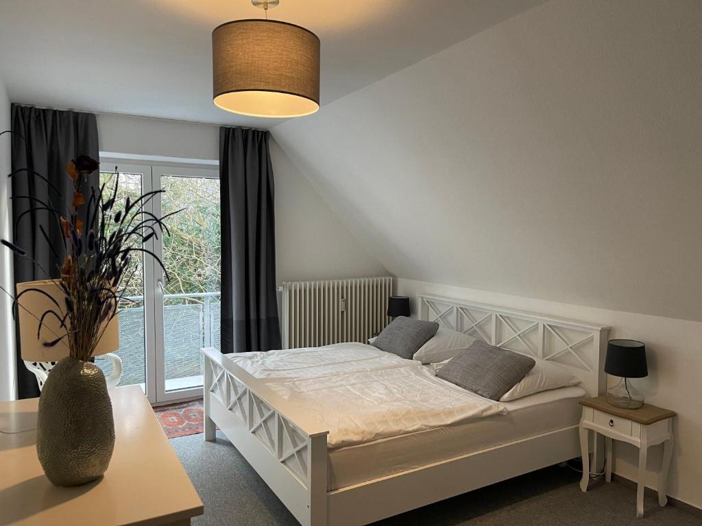 een slaapkamer met een wit bed en een raam bij Wasserblick Stadtidyll 3 Zimmer Apartment Lübeck in Lübeck