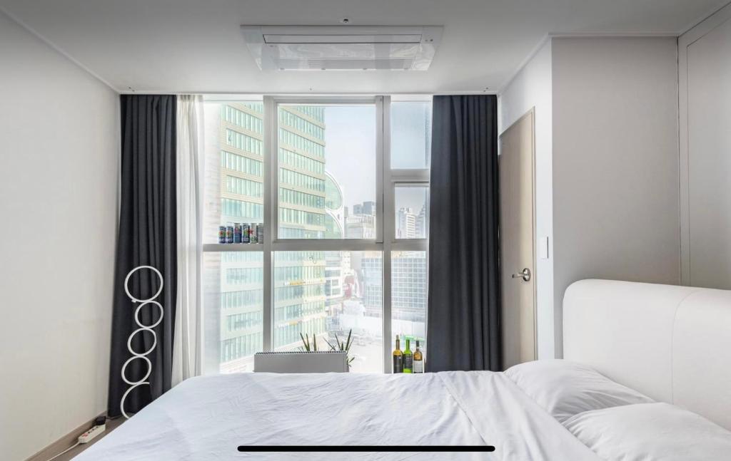 a bedroom with a bed and a large window at Urban Exit Studio Gangnam in Seoul