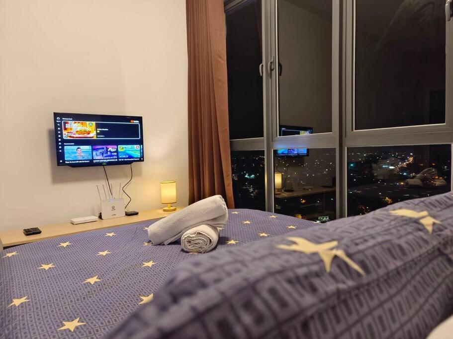 a bedroom with a tv and a bed with stars on it at Troika Residensi Kota Bharu Family Suite by AGhome in Kota Bharu