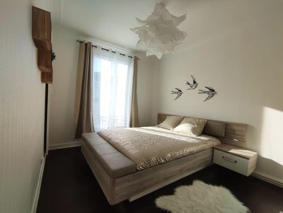 Un pat sau paturi într-o cameră la Appartement proche Paris/Métro