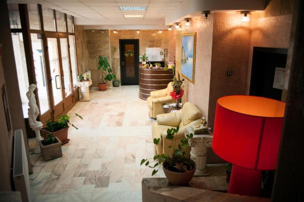 a lobby with couches and potted plants in a building at HOTEL DECENTRIA in Timişoara