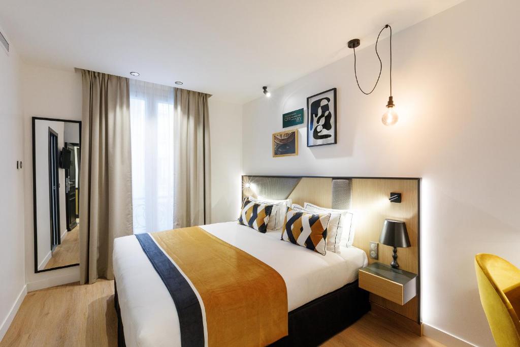a hotel room with a large bed and a window at Star Champs-Elysées in Paris