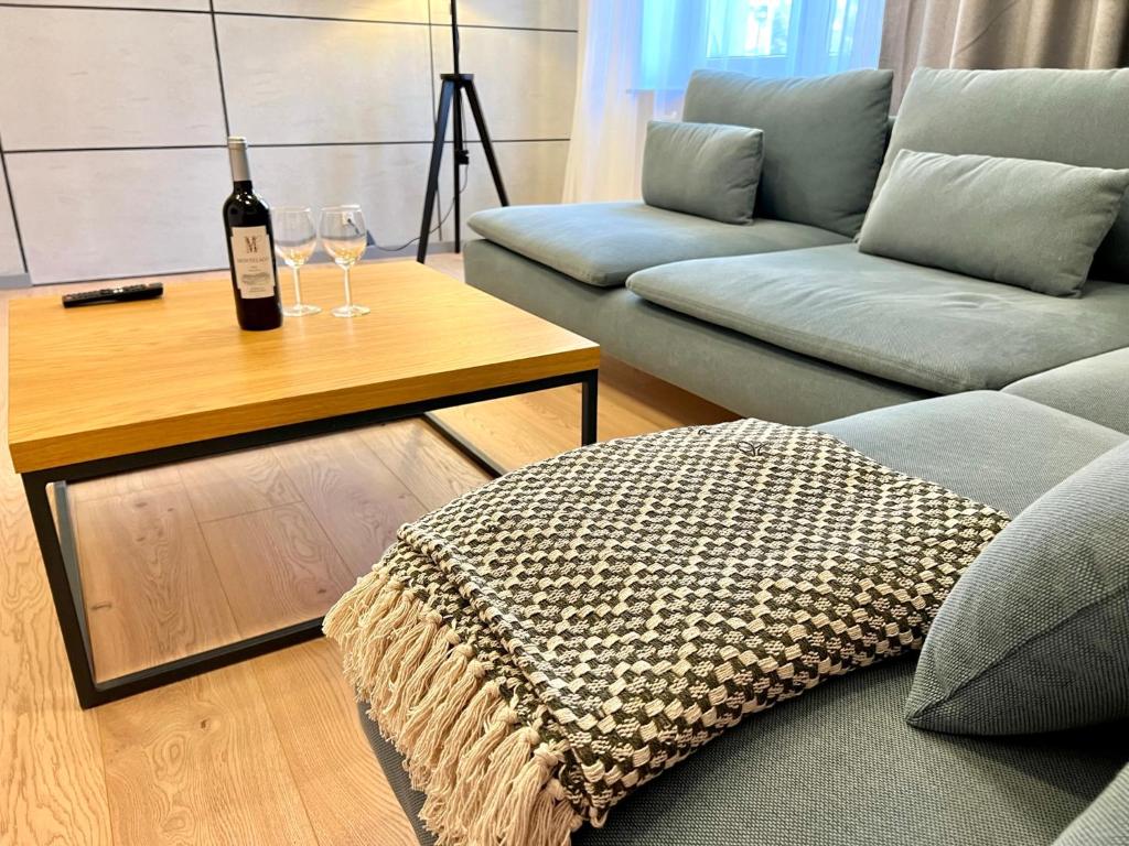 een woonkamer met een fles wijn op een tafel bij Apartament RadMila2 Premium in Radom