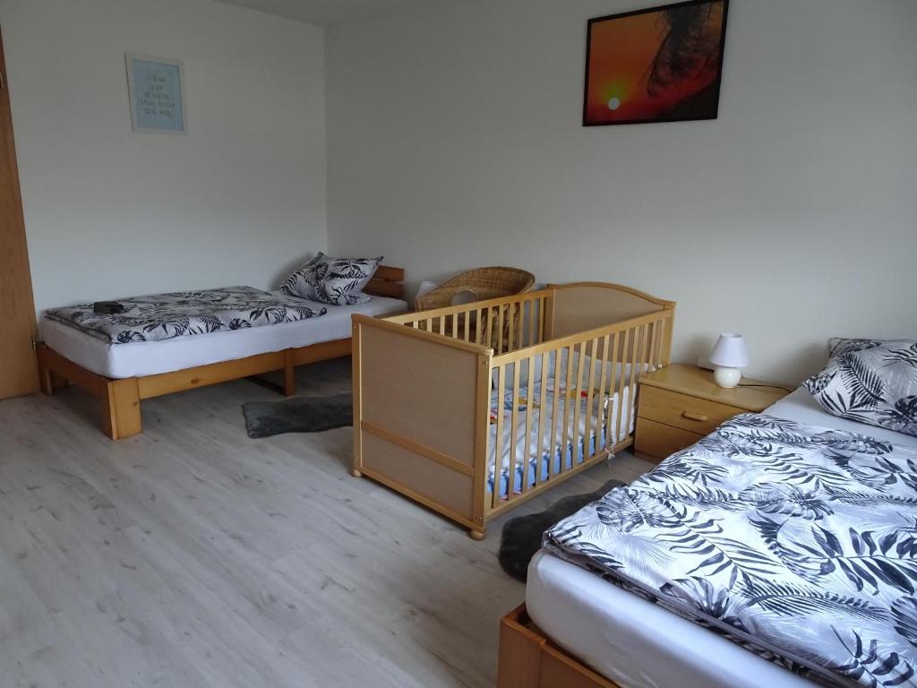 Habitación con 2 camas y cuna en FeWo Mädi, en Windeck