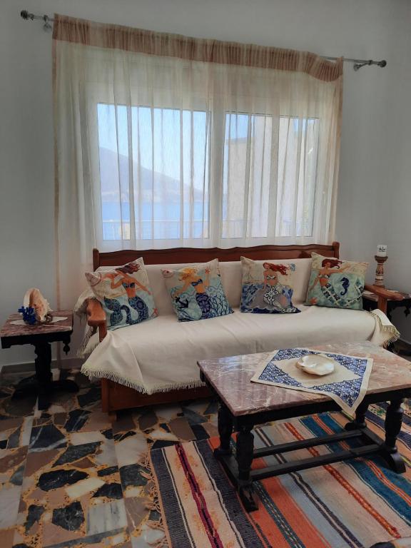 a living room with a couch and a large window at "Gorgones" Mermaids Place in Kalymnos