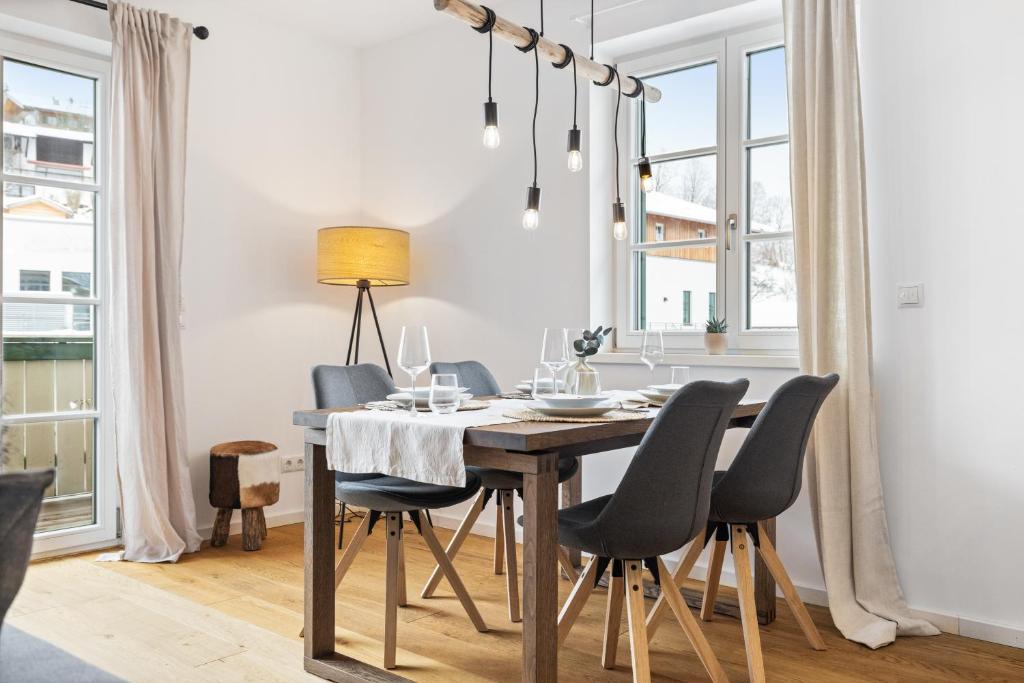 a dining room with a wooden table and chairs at Casa Tegernsee - zentral, modern, Nespresso, 3 Min zum See in Gmund am Tegernsee
