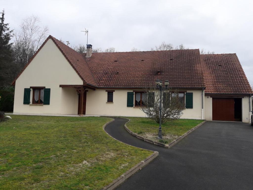 een wit huis met een rood dak en een oprit bij Evènements le Mans et sa région in Challes