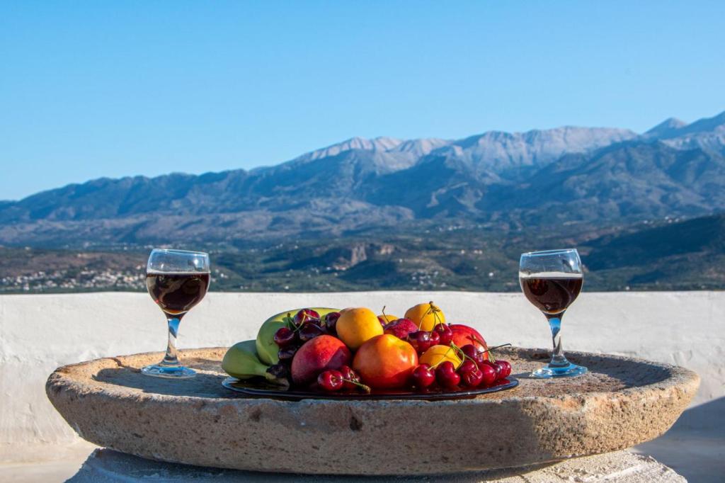 un plato de fruta y dos copas de vino en Bella-Maria at Aptera with mountain and sea view !! en La Canea