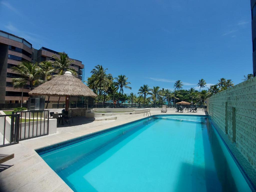 a large swimming pool next to a building at Apartamento na praia de Jatiuca in Maceió