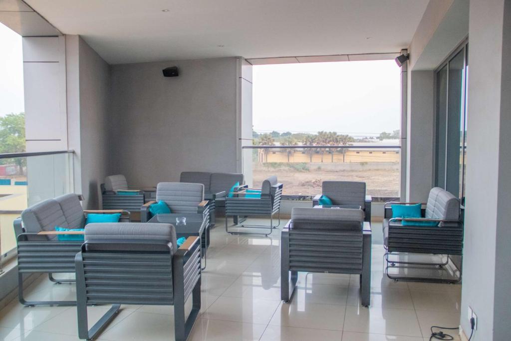 Radisson Blu Hotel, Juba في جوبا: غرفة انتظار فارغة مع كراسي ونافذة كبيرة