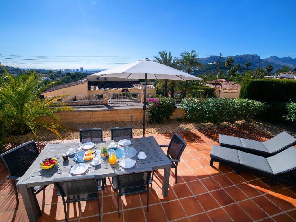 a table with food and an umbrella on a patio at Holiday Home Peeters by Interhome in Calpe