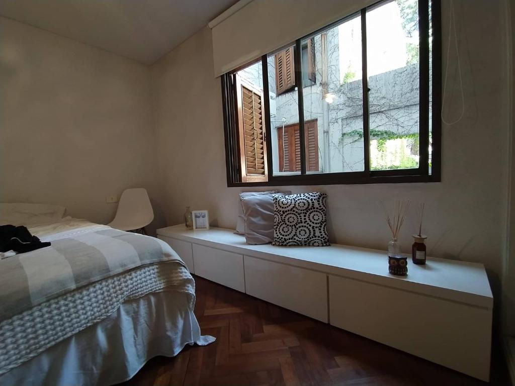 a bedroom with a bed and a window at Welcome from Belgrano R Room in Buenos Aires
