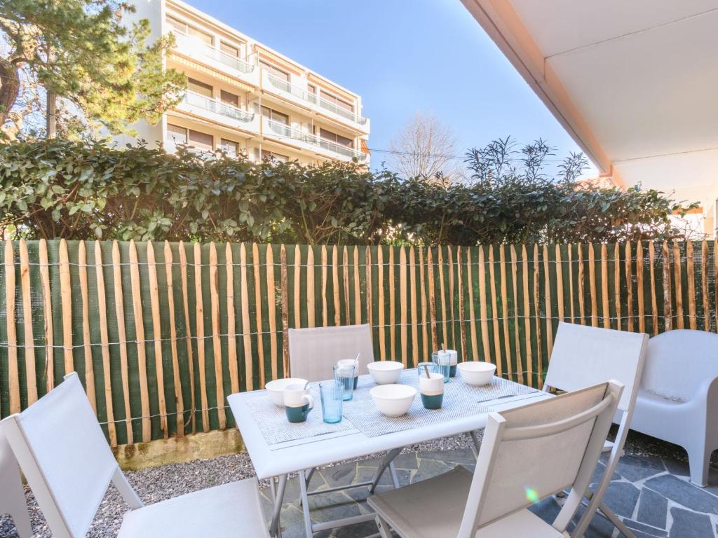 un tavolo bianco e sedie di fronte a una recinzione di Studio le Galion-2 by Interhome ad Arcachon