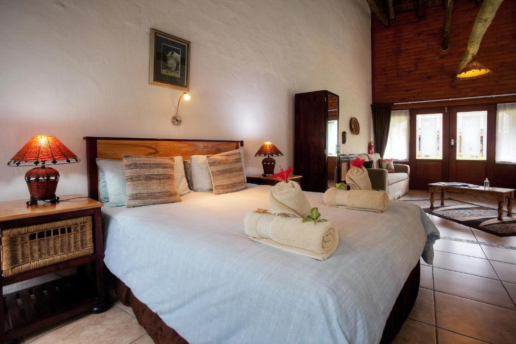 a bedroom with a large bed with two pillows on it at Elephants Footprint Lodge in Colchester